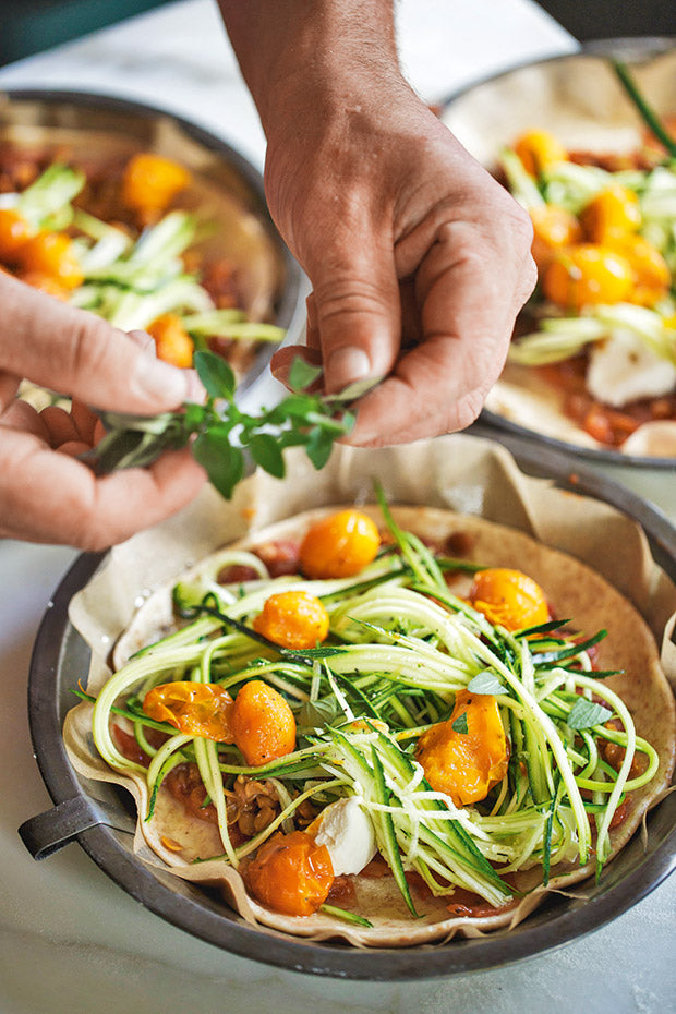 This fresh, homemade pizza is topped with courgette noodles, rocket and soft goat cheese.